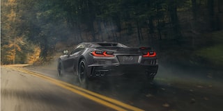 Three Quarters Rear View of a Gray Chevy Corvette E-Ray Going Down the Road