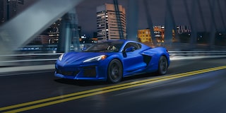 Three Quarters View of a 2025 Blue Chevy Corvette Driving Down the Bridge at Night