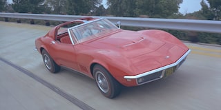 A Rear View of a Red Chevrolet Corvette Convertible with Chrome Bumper and Round Taillights.