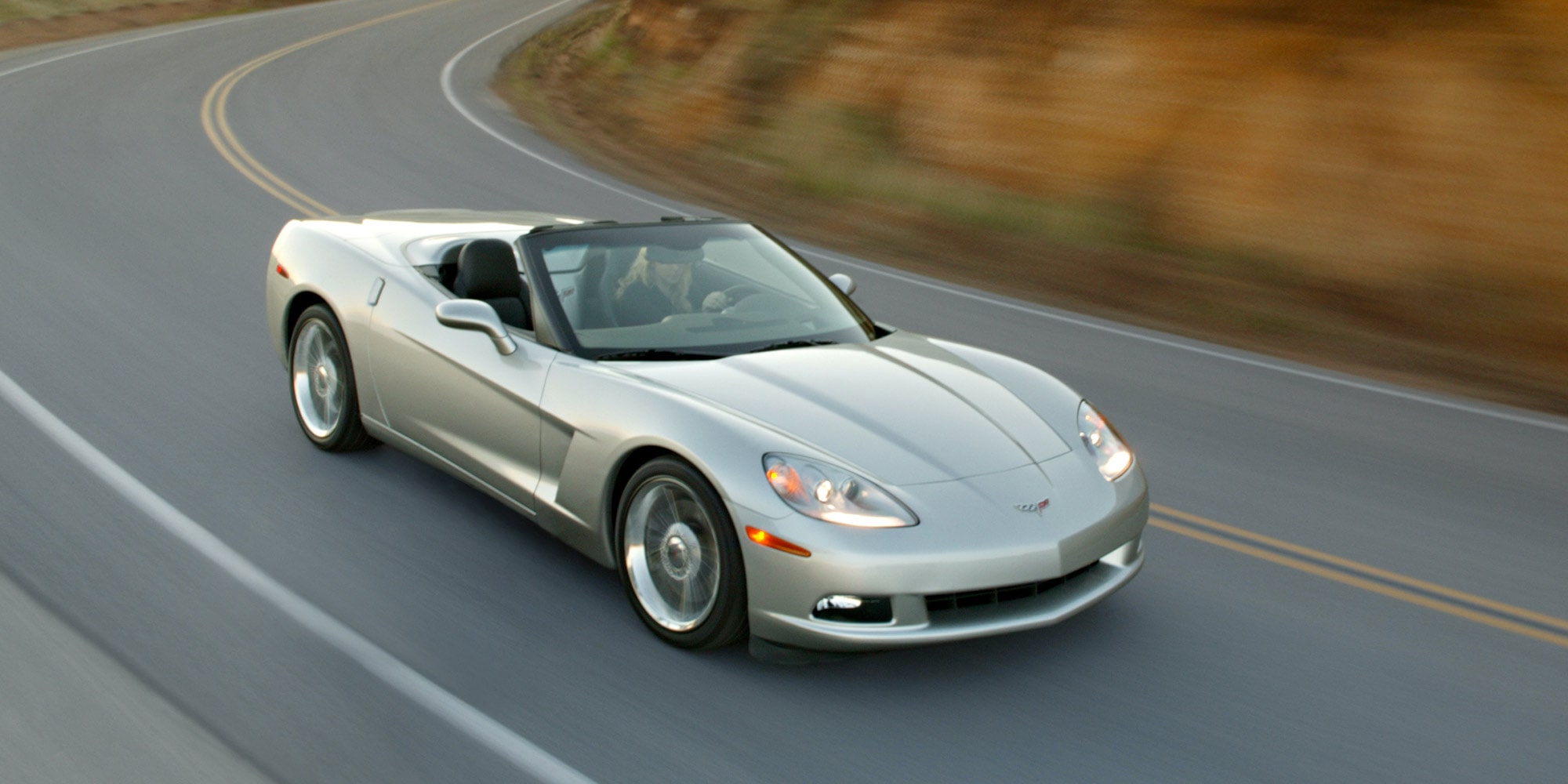 Dreiviertel-Luftaufnahme eines silbernen Corvette Z06 Cabriolets auf einer Autobahn.