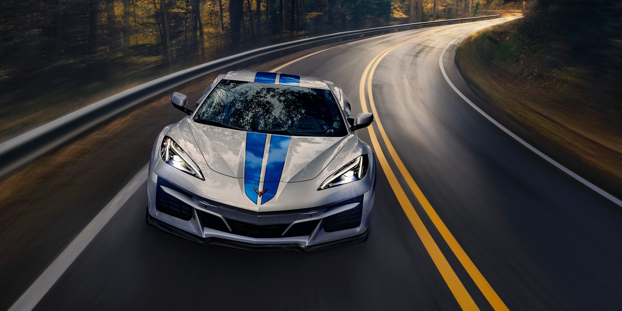 Ein Corvette E-Ray (2024) mit doppeltem Rennstreifen bei voller Fahrt auf der Rennstrecke.