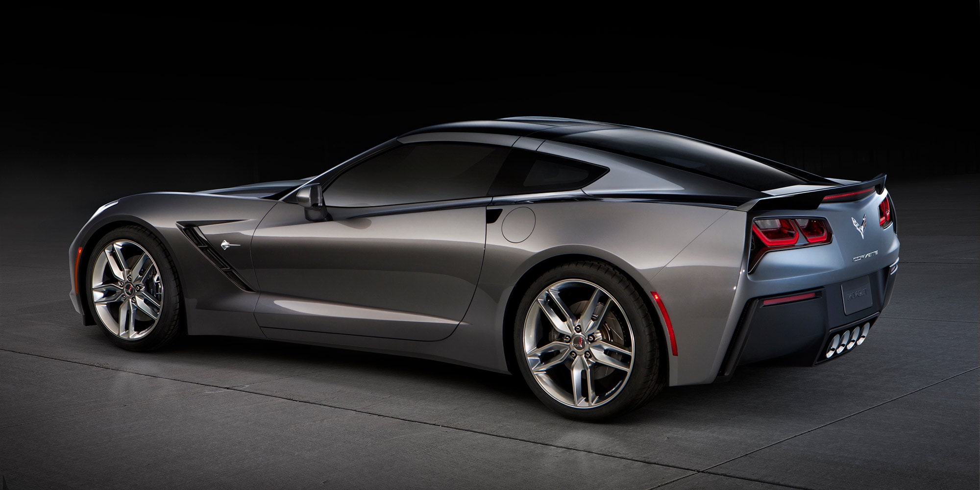 Dreiviertel-Heckansicht eines Corvette Stingray C7 in Cyber Gray Metallic mit silbernen Felgen.