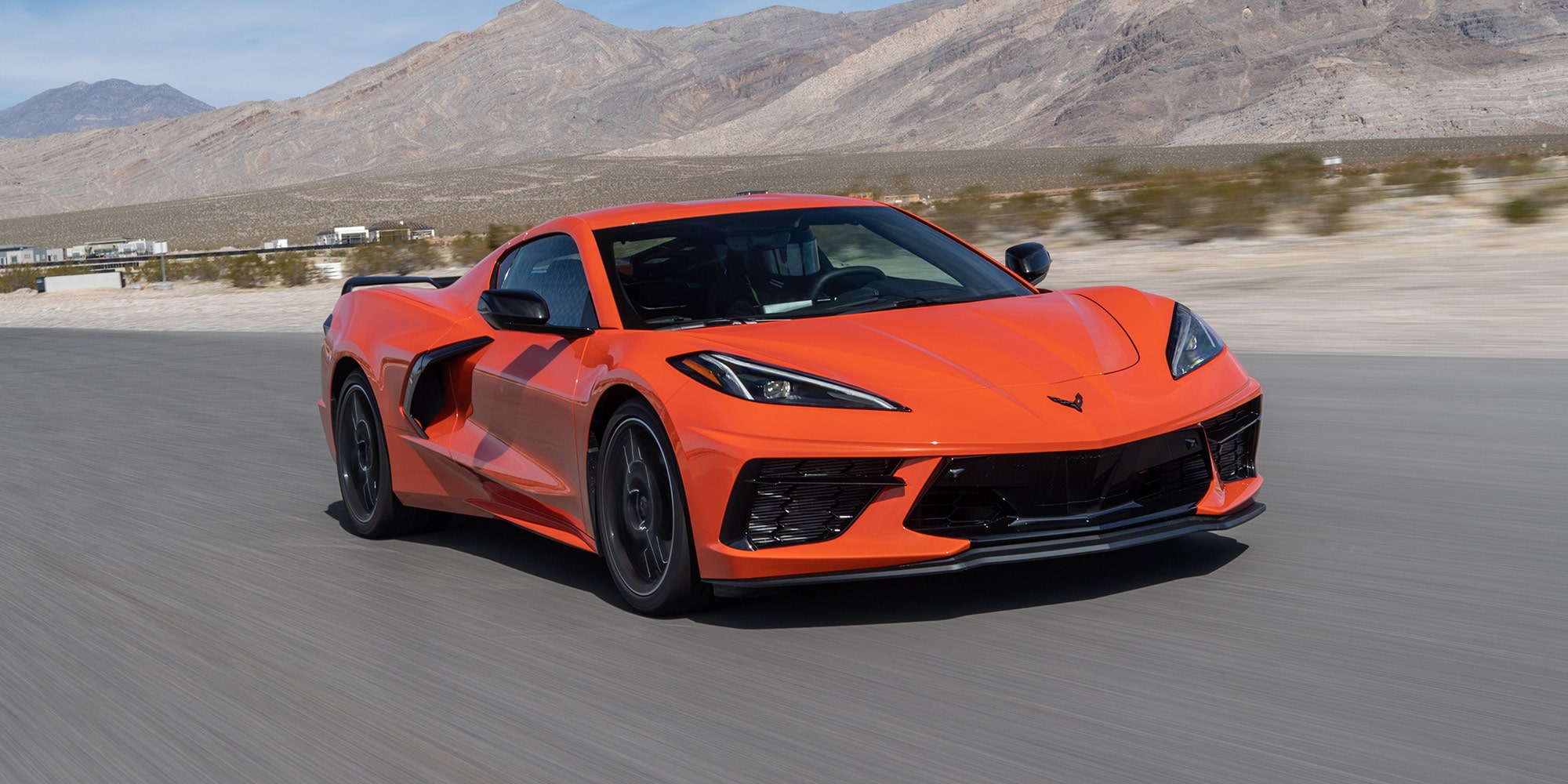 Dreiviertelansicht eines Chevrolet Corvette Stingray C8 auf einer Wüstenstraße.