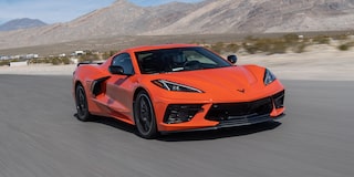 An Orange Chevrolet Corvette Z06 Sports Car Parked on a Desert Road with Aggressive Front Styling and Black Accents.