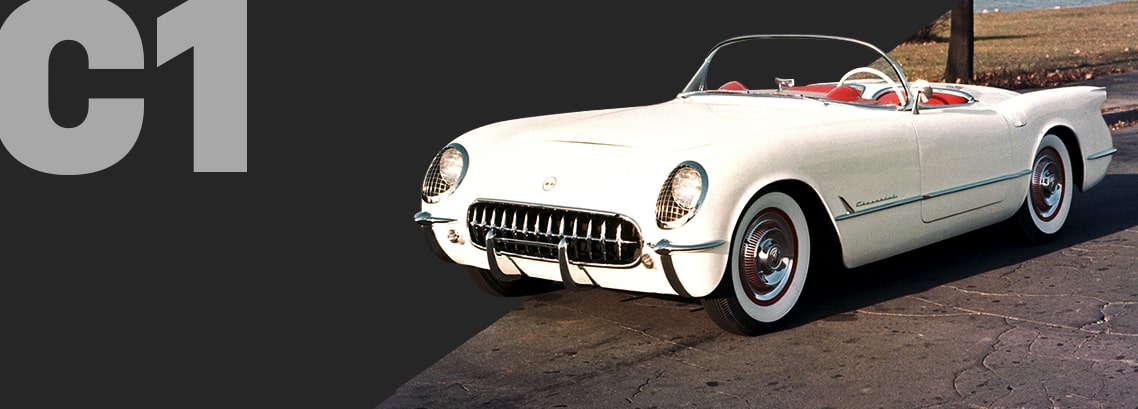Three-quarter view of a Polo White Corvette C1 convertible, parked outside.