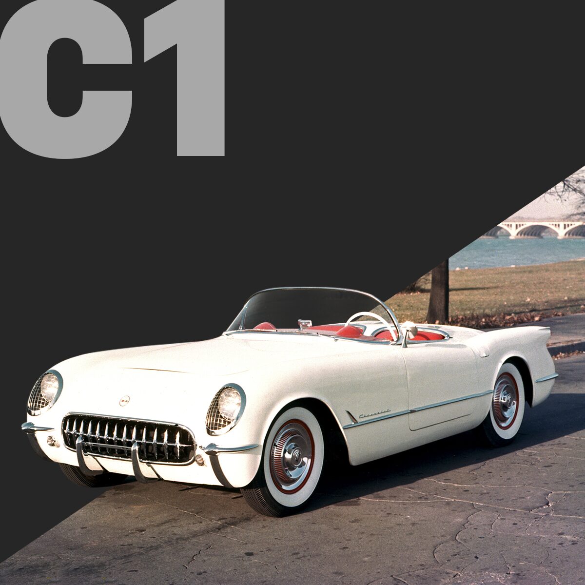 Three-quarter view of a Polo White Corvette C1 convertible, parked outside.
