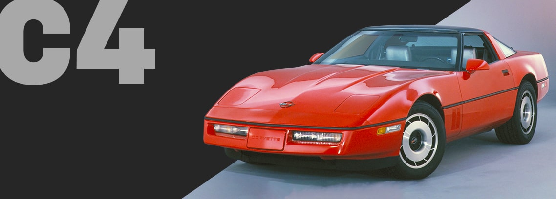 Three-quarter view of a brilliant-red Corvette C4 coupé, parked on cement.