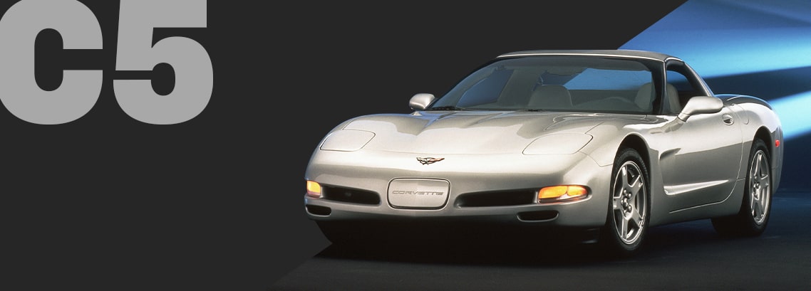 Three-quarter view of a silver Corvette C5 coupé, parked in a showroom.