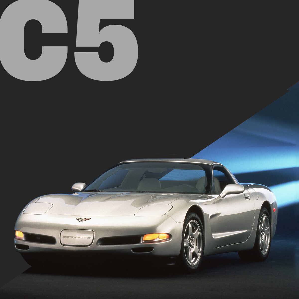 Three-quarter view of a silver Corvette C5 coupé, parked in a showroom.