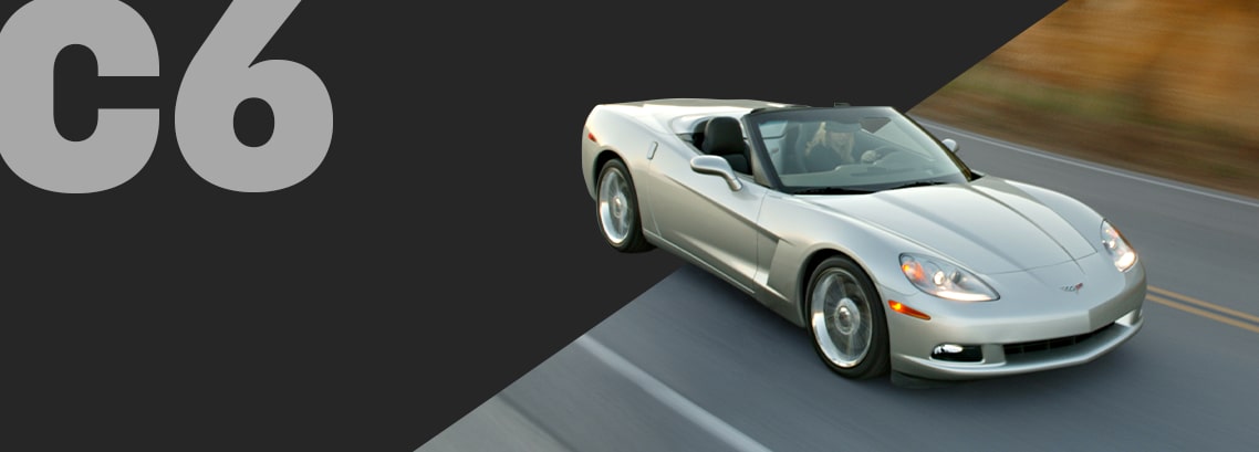 Three-quarter view of a silver Corvette C6 convertible, burning rubber on a highway
