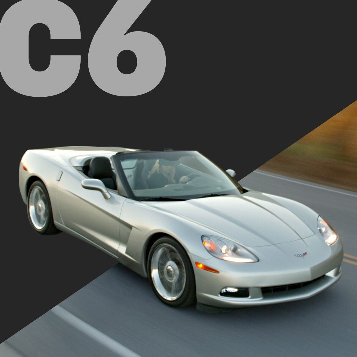 Three-quarter view of a silver Corvette C6 convertible, burning rubber on a highway