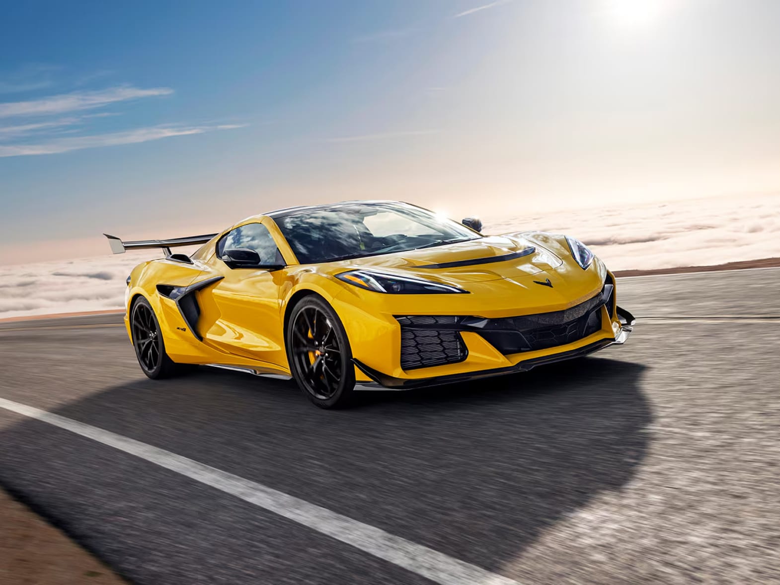 Three-quarter view of a Chevy Corvette ZR1 hypercar. Finished in Competition Yellow Tintcoat Metallic, and pounding a racetrack.