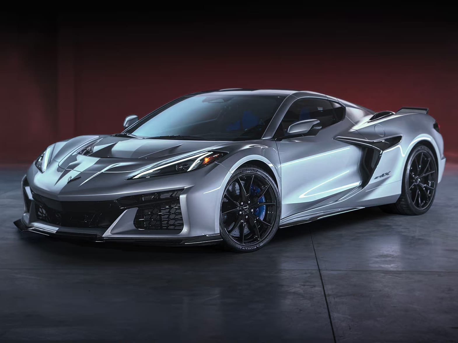 Three-quarter view of a Chevy Corvette ZR1X hypercar. Finished in Blade Silver Metallic, and parked on polished paving slabs.