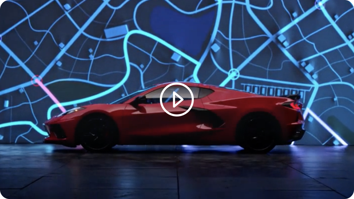 Side View of a 2025 Red Chevy Corvette Stingray Next to Speeding Light Effects