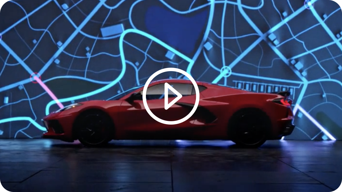 Side View of a 2025 Red Chevy Corvette Stingray Next to Speeding Light Effects