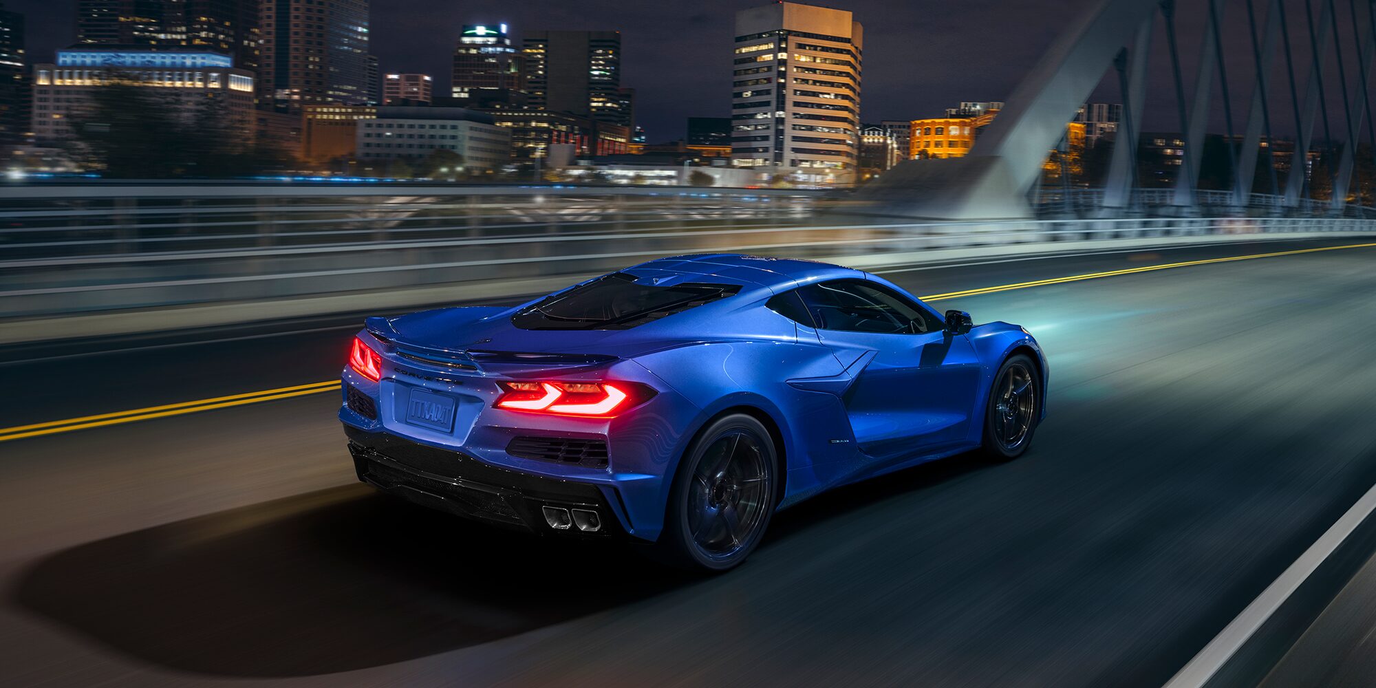 Three Quarters View of a 2025 Blue Chevy Corvette E-Ray in an Icy Plain Surrounded by Icy Mountains